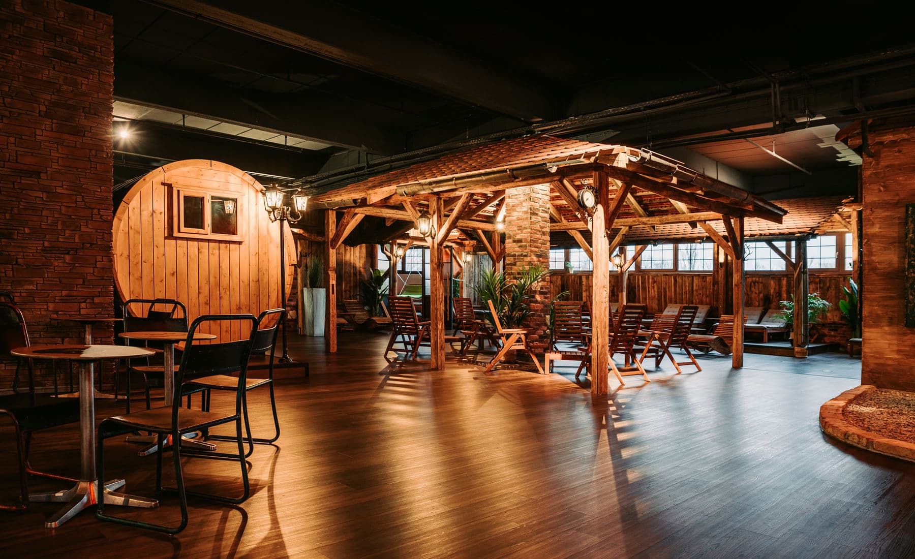 Saunalandschaft im Panther Gym — Fass-Sauna, Holzpergola und Ruhebereich